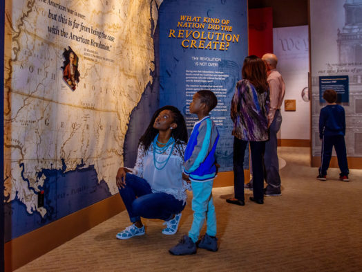 A woman and child look at a map at the Museum of the American Revolution