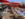 The roof deck at Azie in Media, Pennsylvania, featuring red umbrellas, metallic silver tables, and white chairs on a sunny day.