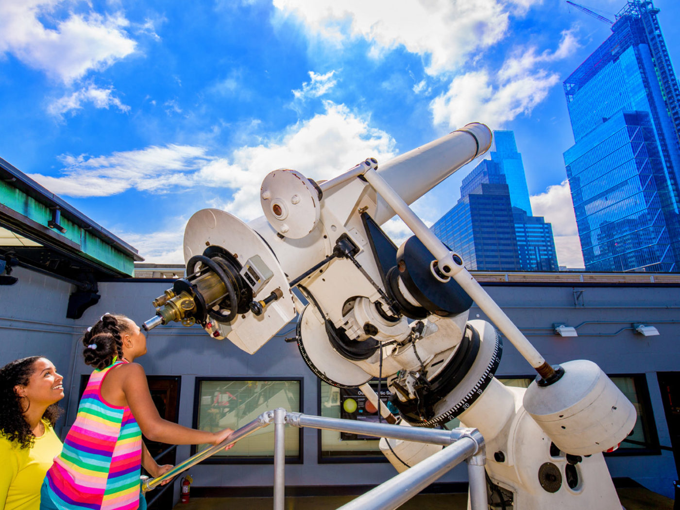 Chica mirando por el telescopio en The Franklin Institute