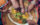 Five hands holding bread dipping into a dish at the center of a table