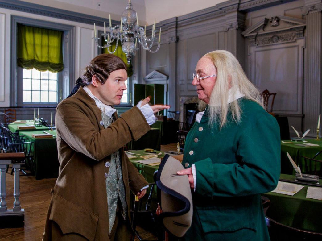 John Adams and Ben Franklin debate in Independence Hall in Philadelphia