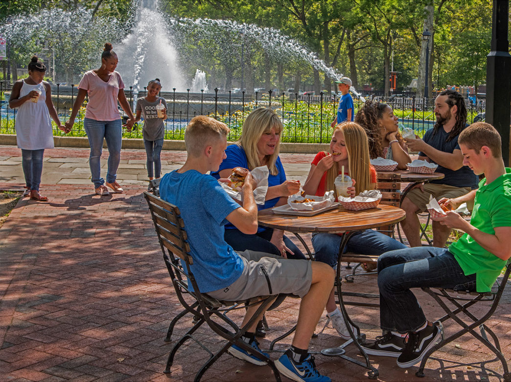 Gezinnen zitten buiten in Franklin Square in Philadelphia