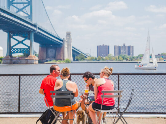 People hanging out near the Delaware River at Cherry Street Pier in Philadelphia