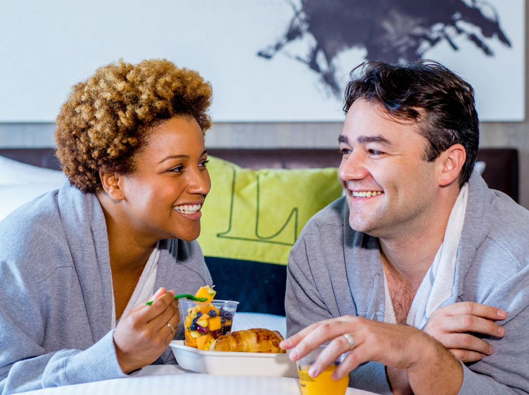 Couple eating breakfast in bed at The Logan hotel in Philadelphia