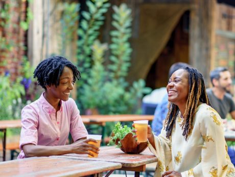 Two women enjoy a beer and laugh at PHS Pop Up Garden at South Street in Philadelphia
