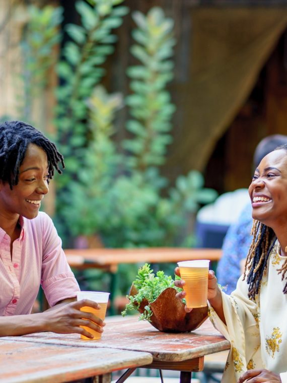 Two women enjoy a beer and laugh at PHS Pop Up Garden at South Street in Philadelphia