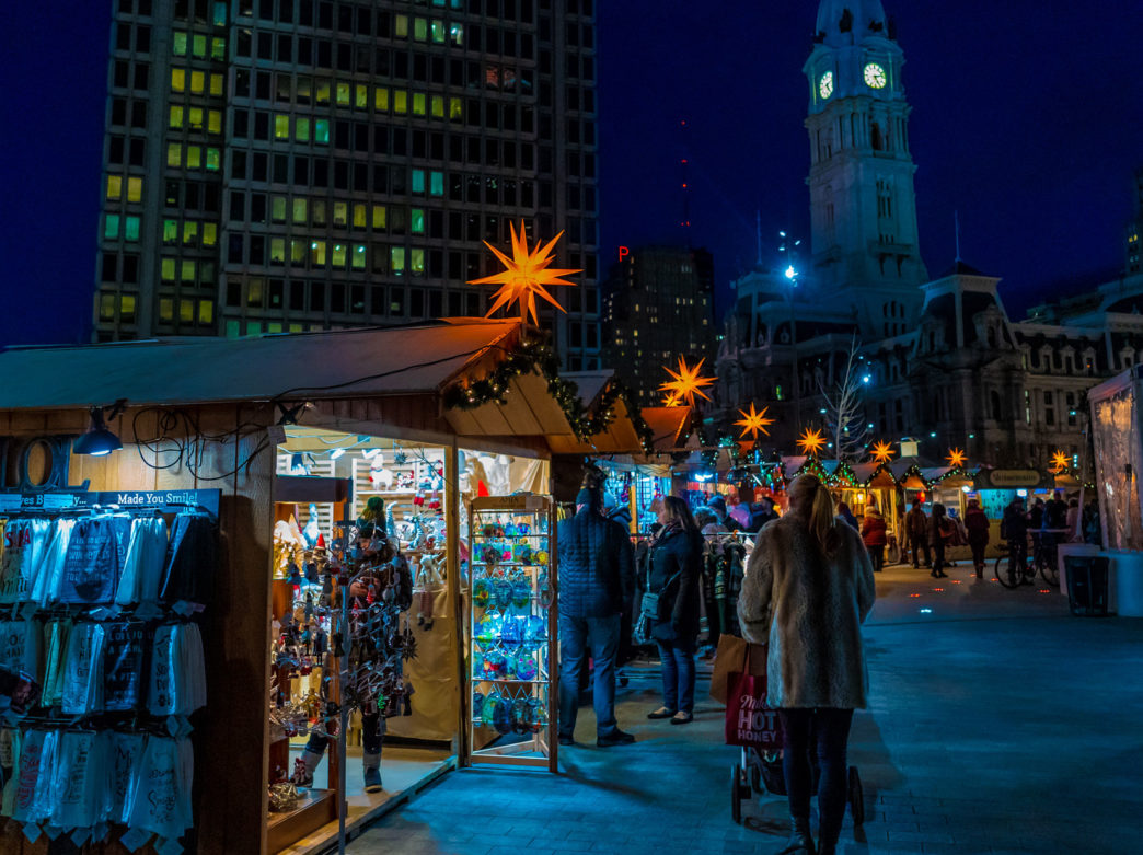 Shoppers in winter gear browse vendors in wooden booths at the annual Christmas Village in Philadelphia in Love Park