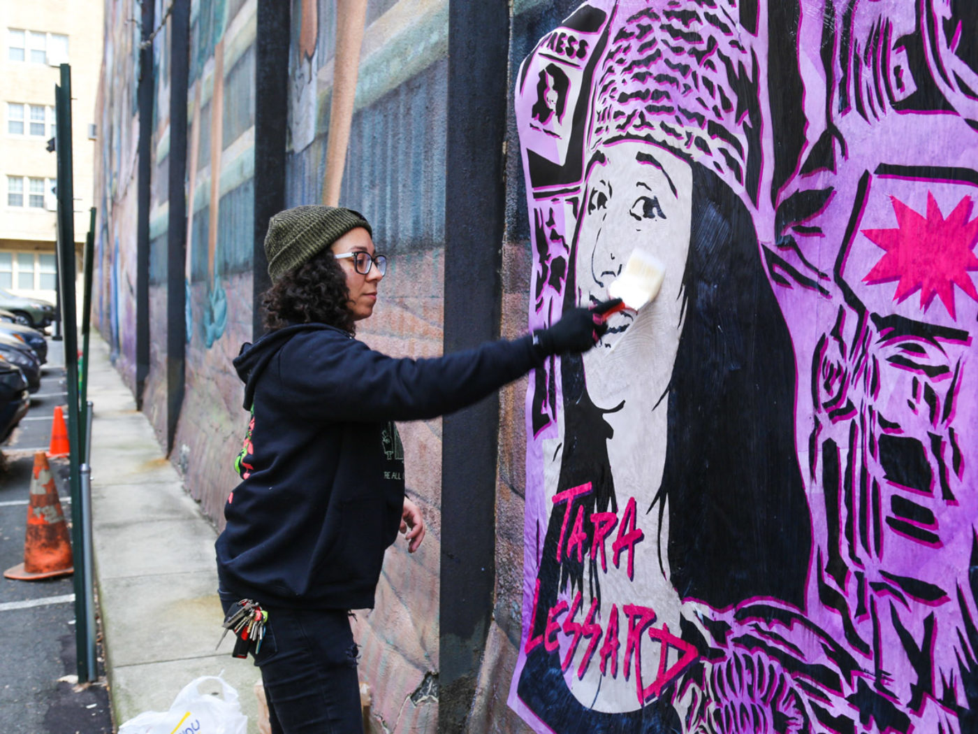 Artist Taped Off TV works on her wheatpaste artwork depicting Tara Lessard.