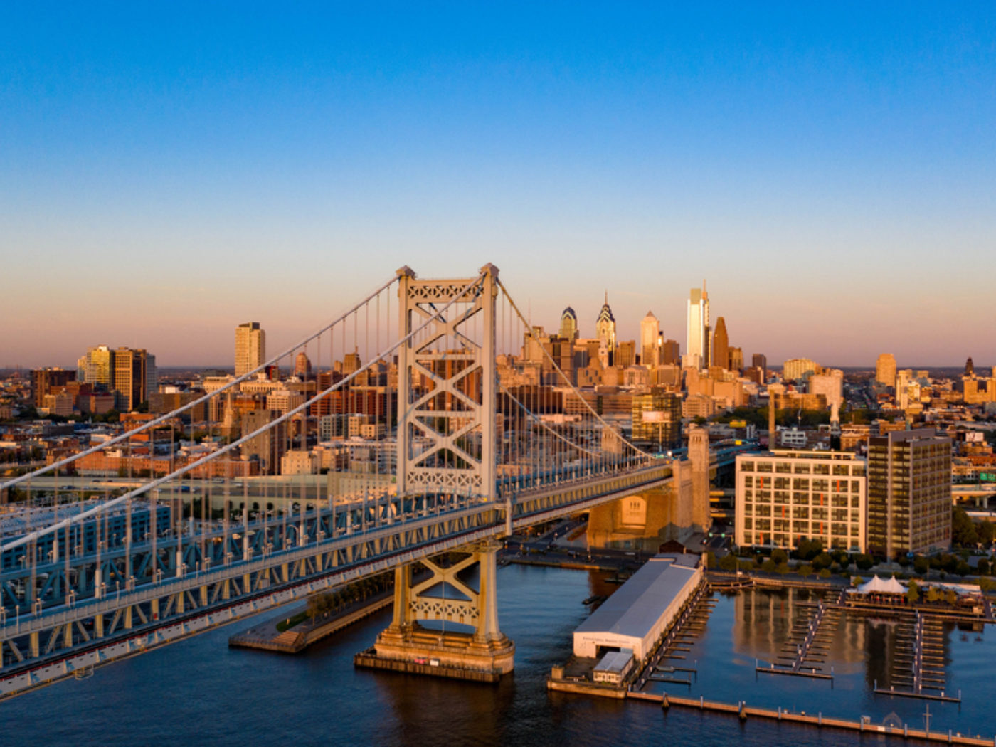 A drone shot of the Benjamin Franklin Bridge with the Philadelphia skyline in the background