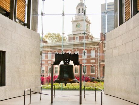 The Liberty Bell with no people around and Independence Hall in the background