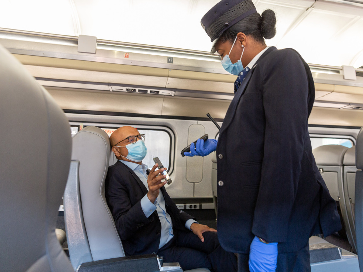 A person checks a ticket on an Amtrak train