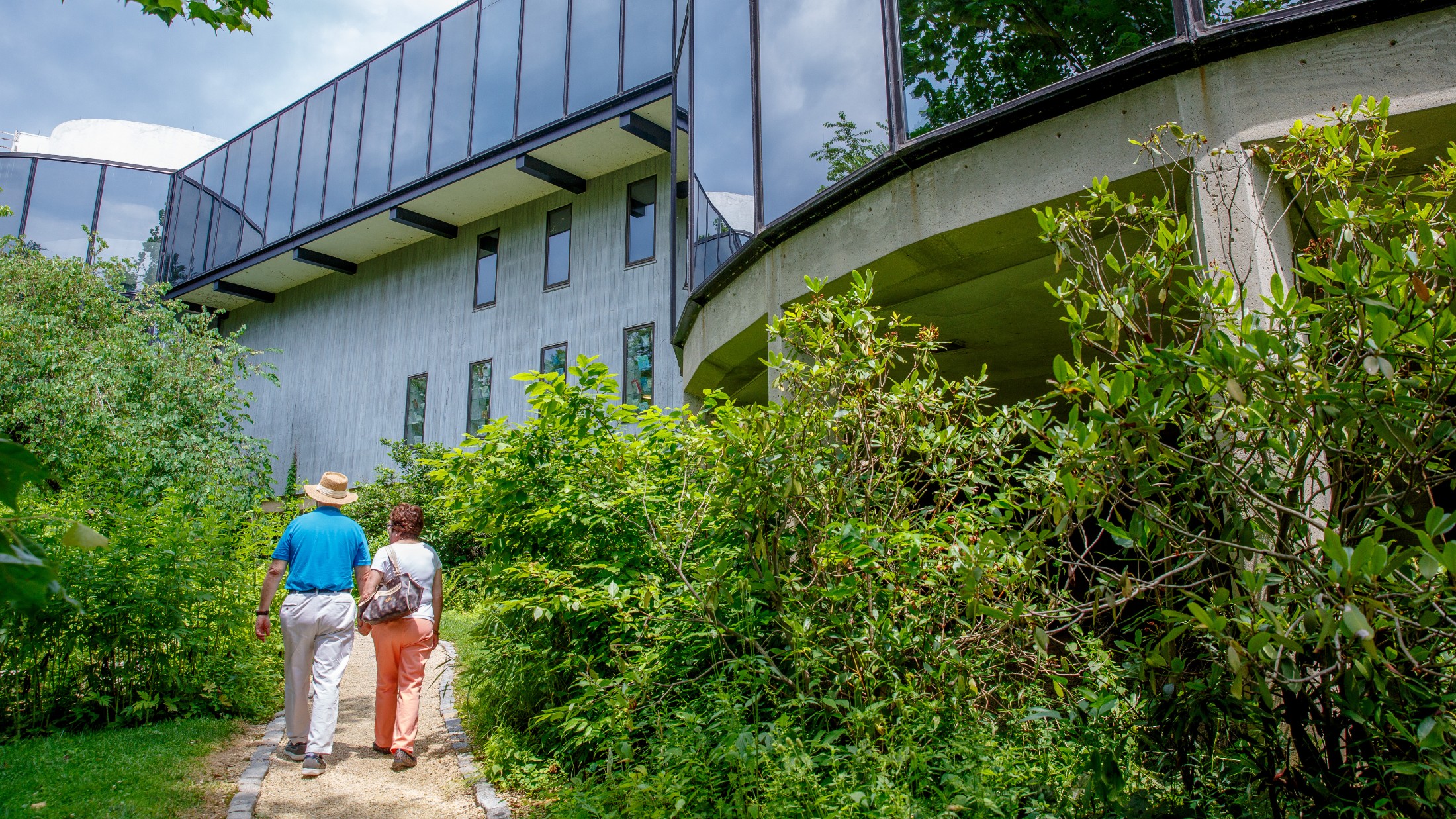 A couple walks through some greenery outside the Brandywine River Museum of Art