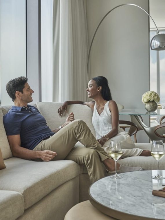 Couple in a suite at the Four Seasons Hotel Philadelphia with the Philly skyline in the background