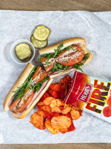 A hoagie with a bag of Herr's FIre Chips