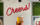 A hand holds up a beer in front of.a wall that reads Cheers at Workhorse Brewing COmpany