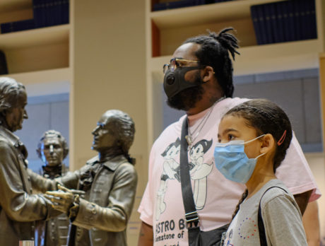 A family wearing masks explores the National Constitution Center in Philadelphia