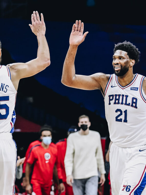 Joel Embiid of the Philadelphia 76ers high fives his teammates