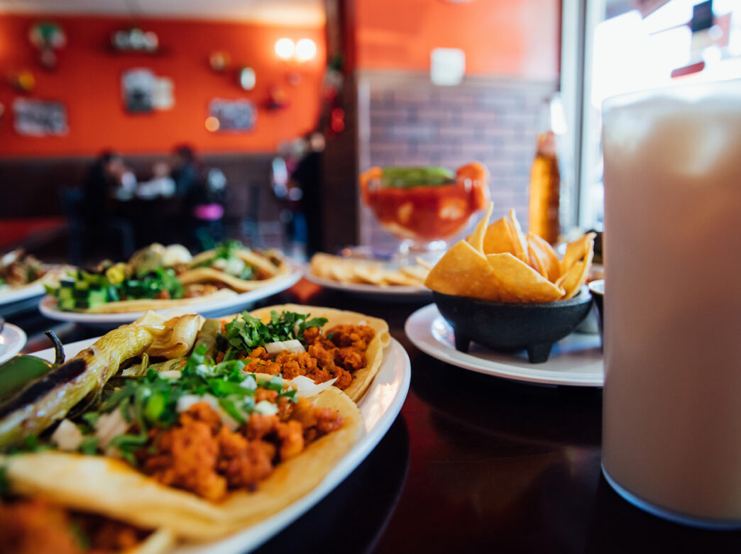 Comida, como tacos y nachos, y bebidas en una mesa del restaurante Adelita, en Filadelfia.