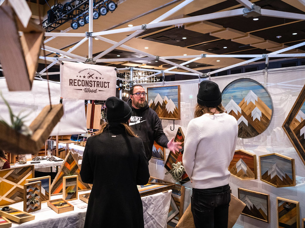 A person at the Art Star Craft Bazaar speaks to prospective customers