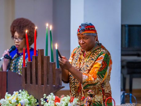 A person lights the kinara during a Kwanzaa celebration at The African American Museum in Philadelphia
