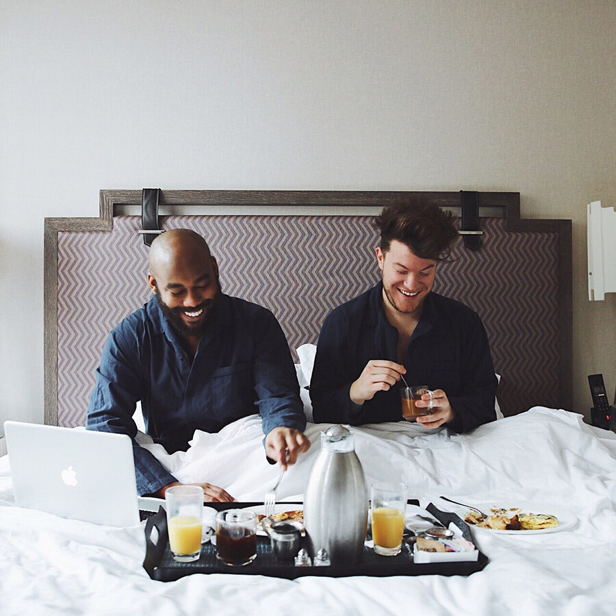 A couple enjoys breakfast in bed at the Kimpton Hotel Palomar