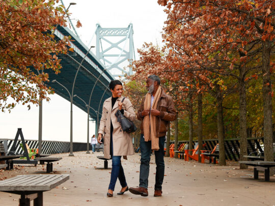 A couple strolls on Race Street Pier in Philadelphia