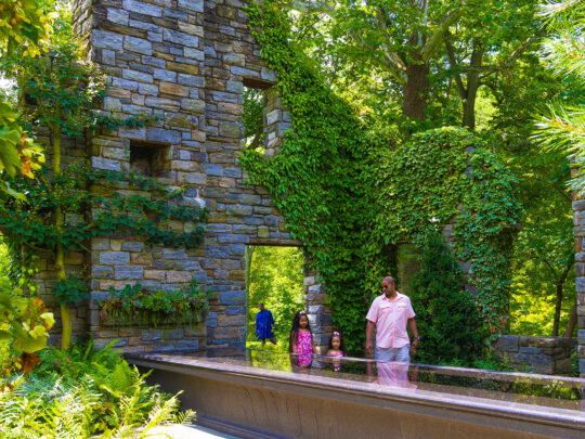 A family walks through the ruins at Chanticleer