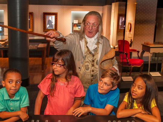 Um ator que interpreta Benjamin Franklin conversa com crianças no Museu Benjamin Franklin, na Filadélfia.