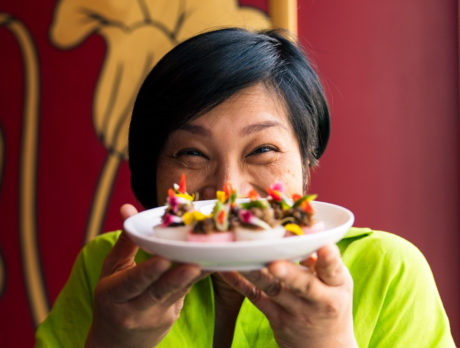 Chutatip “Nok” Suntaranon from Kalaya Thai Kitchen holds up a plate of food in front of her face