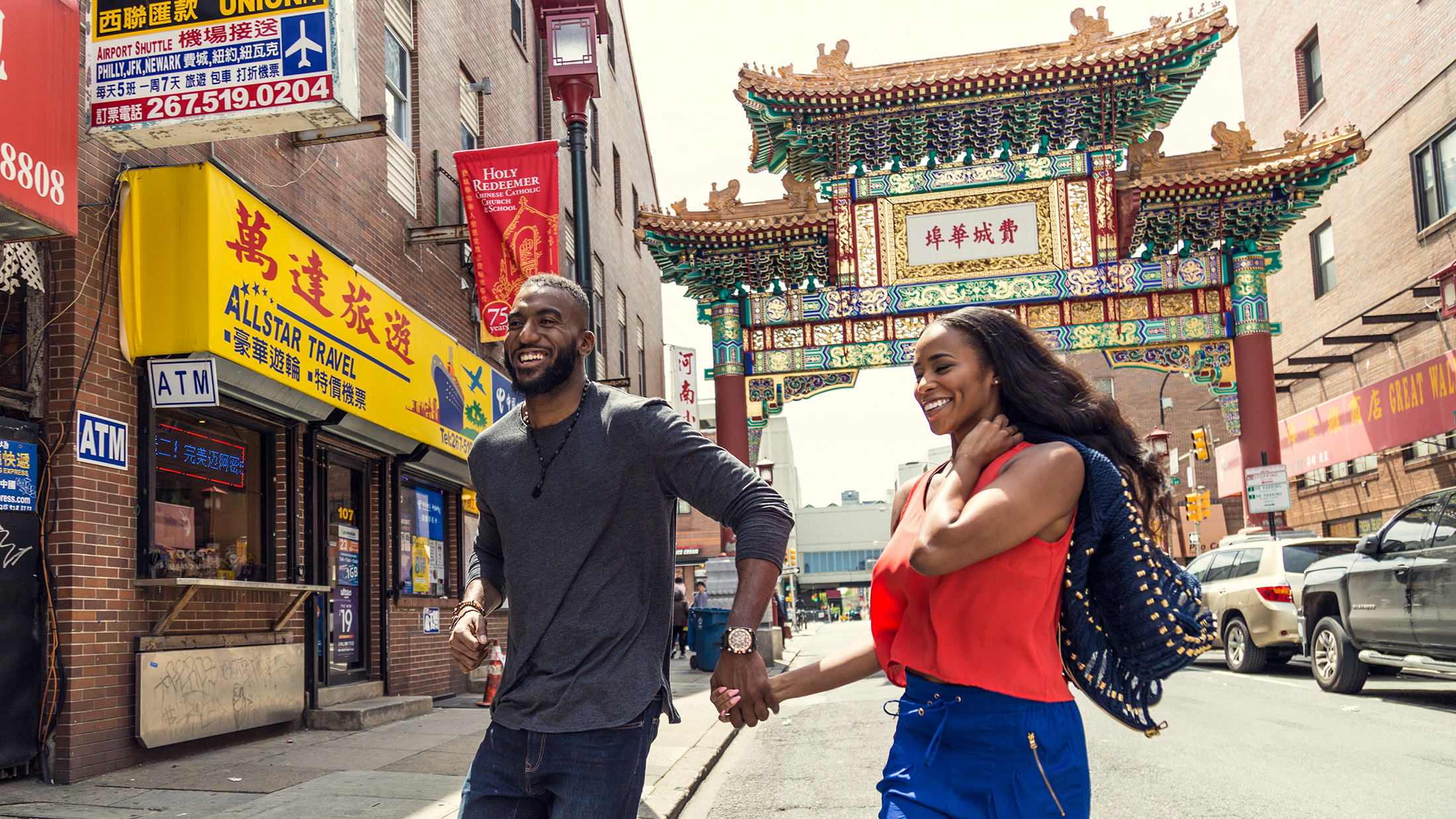 A couple crosses the street in front of the Chinatown Arch in Philadelphia