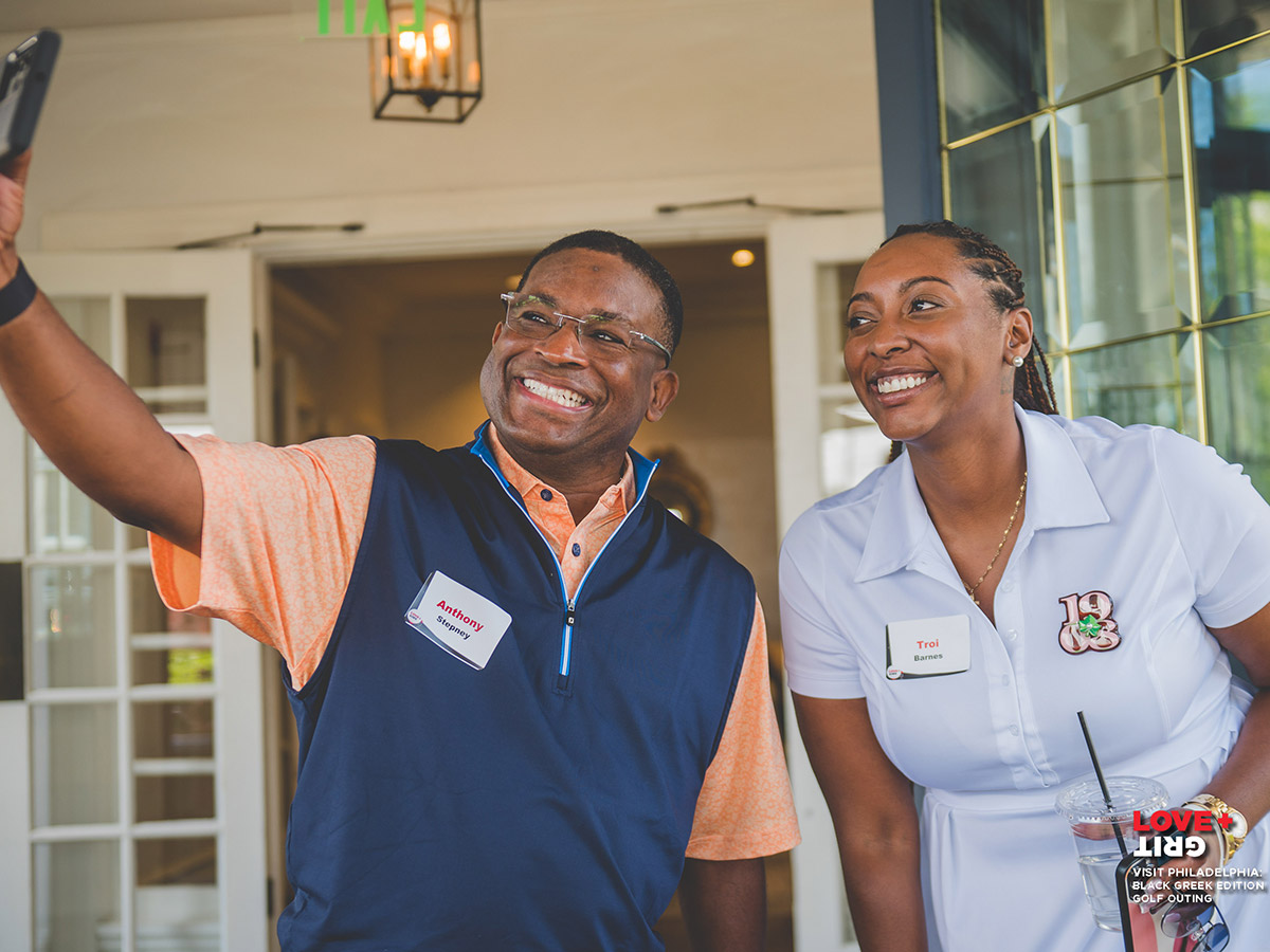 Two people dressed to play golf take a selfie