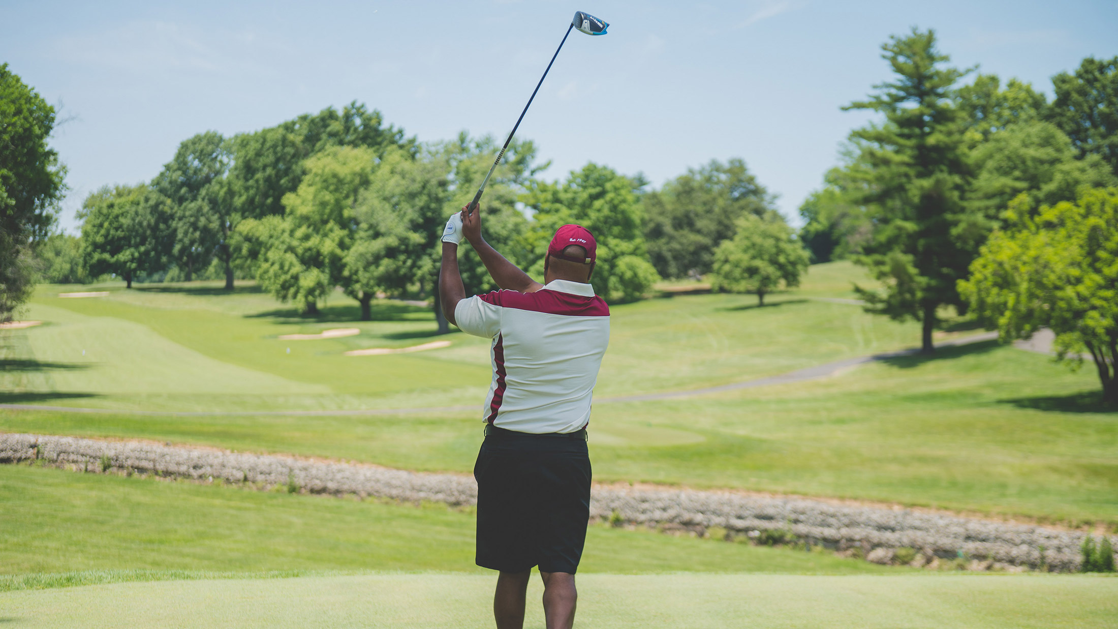A person finishes a golf swing during the Visit Philadelphia: Black Greek Edition Golf Outing