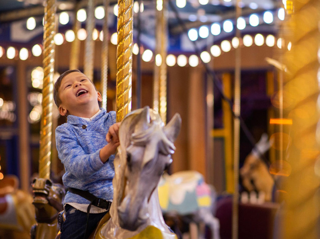 A young boy rides the carousel at Giggleberry Fair