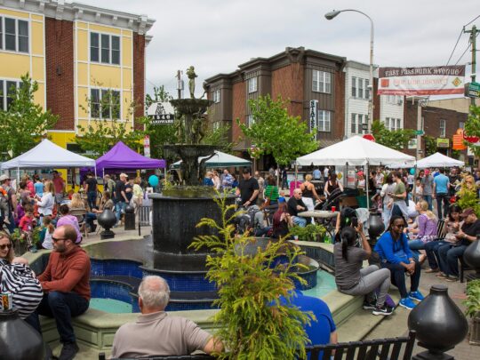 A crowd around the Singing Fountain during Flavors on the Avenue