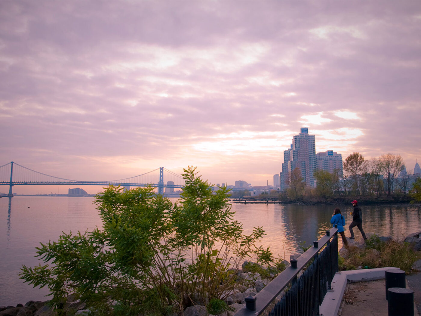 Two people stand by the water at Penn Treaty Park