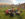 People sit in a circle in Adirondack chairs in the courtyard of Eastern State Penitentiary with the skyline of Philadelphia in the distance