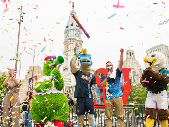 Las mascotas de los equipos deportivos de Filadelfia celebran mientras cae el confeti durante una fiesta de animación para la Copa Mundial de la FIFA en Love Park.