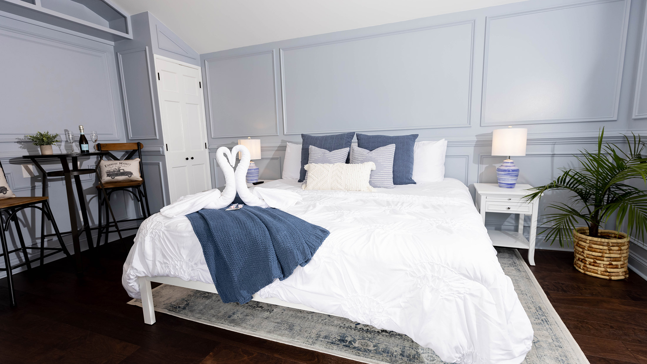 Um quarto de hotel com uma cama branca e duas toalhas amarradas como cisnes no Wintewing
