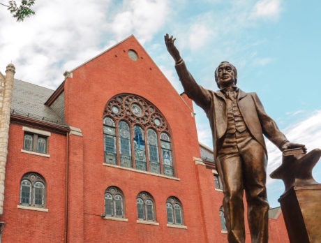 The red exterior of Mother Bethel Church in Philadelphia, with a statue of Richard Allen raising his hand in front of the church