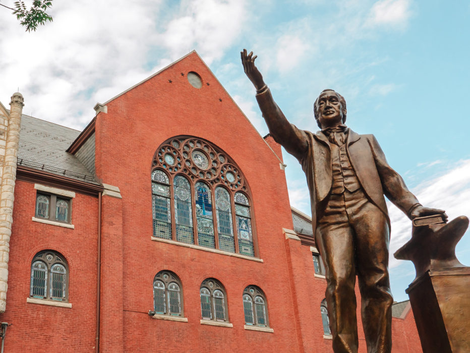 The red exterior of Mother Bethel Church in Philadelphia, with a statue of Richard Allen raising his hand in front of the church
