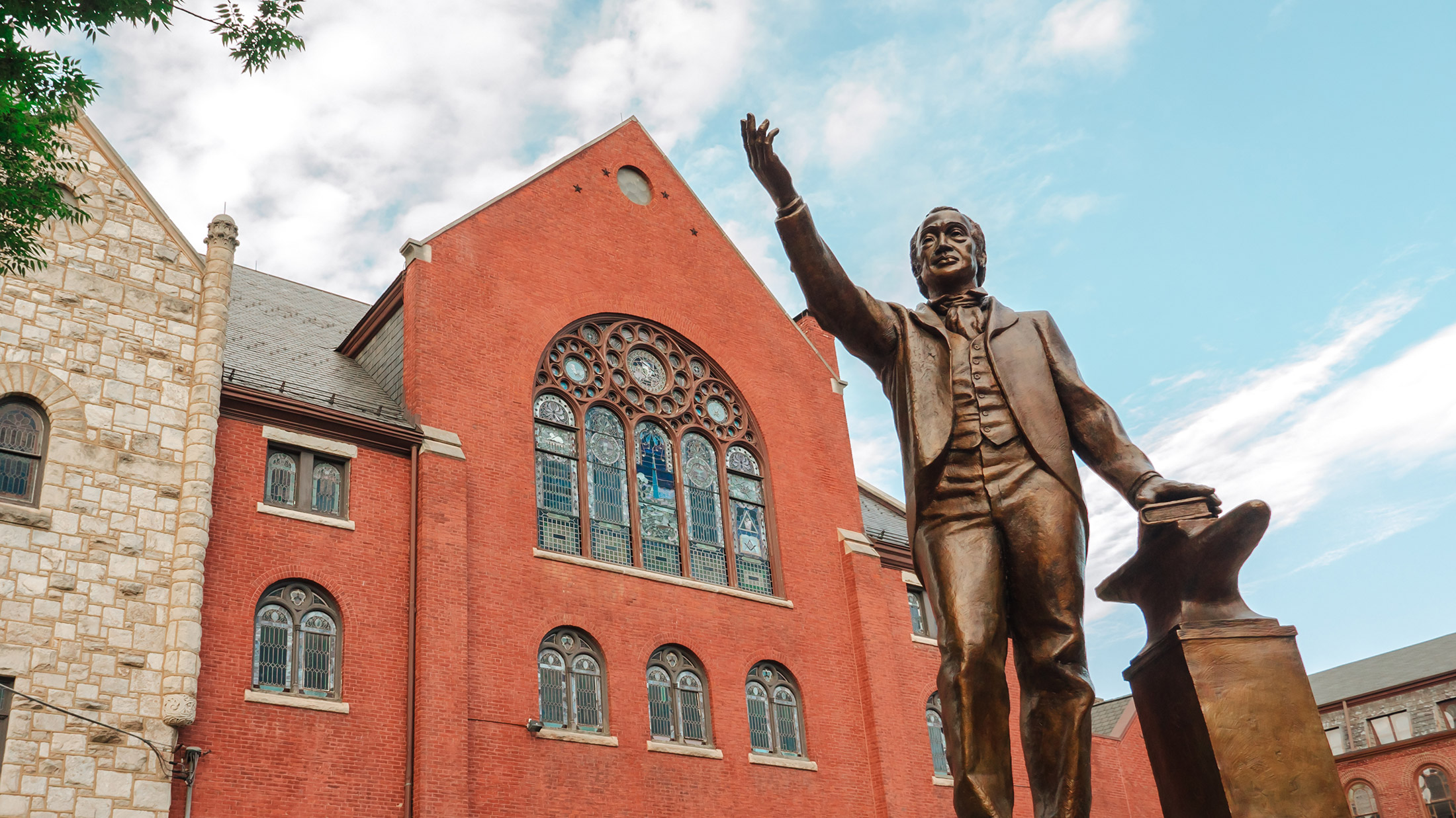 The red exterior of Mother Bethel Church in Philadelphia, with a statue of Richard Allen raising his hand in front of the church