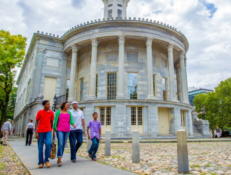 A family walks past the Merchants Exchange building in Old City Philadelphia