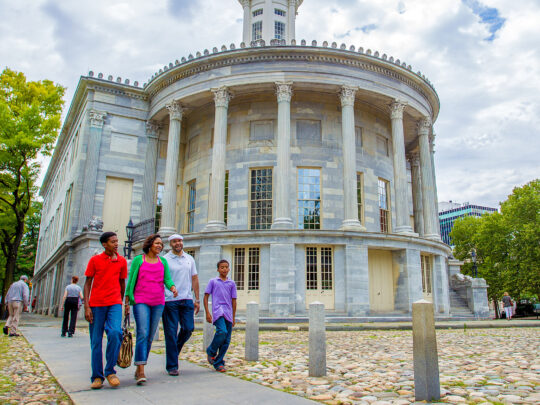 Una familia pasa por delante del edificio Merchants Exchange en Old City Filadelfia