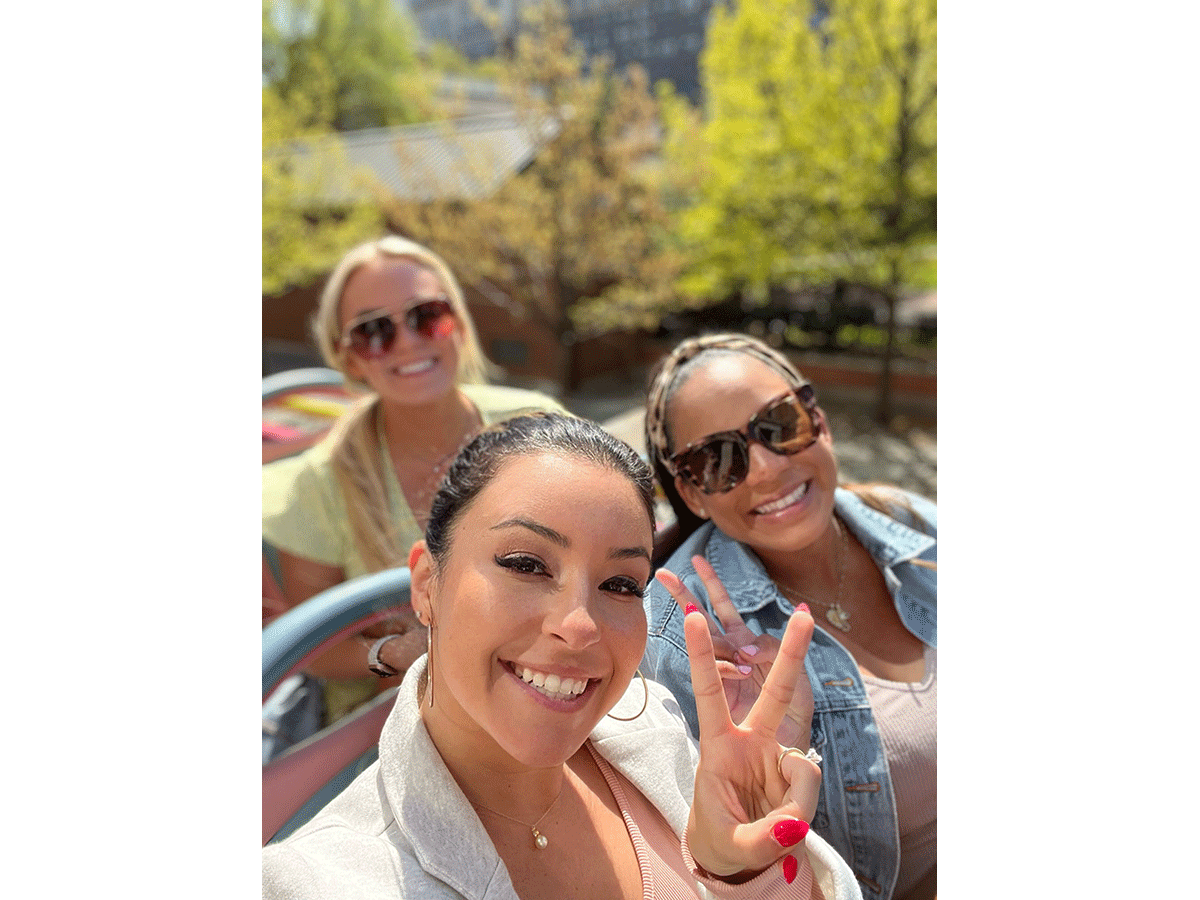 Three people smile at the camera on the Philadelphia Sightseeing Bus