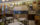 The interior of Samuel's in Philadelphia. Empty tables and chairs on a tiled floor, with a wall in the background covered in frames.