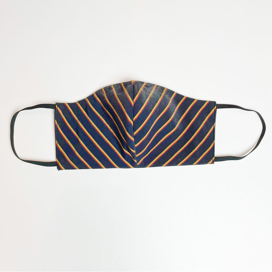 A face mask against a gray background. The mask has yellow stripes and is blue.