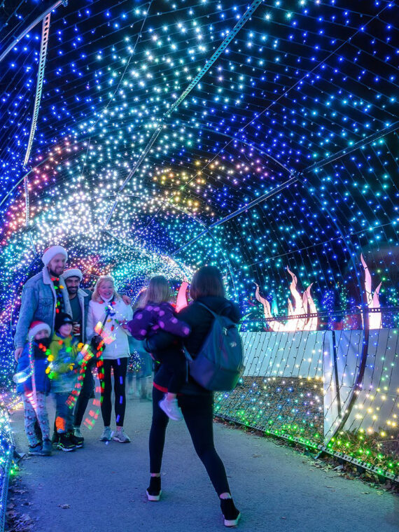 A family poses for a picture inside of a "tunnel" of illuminated lights at the Philadelphia Zoo