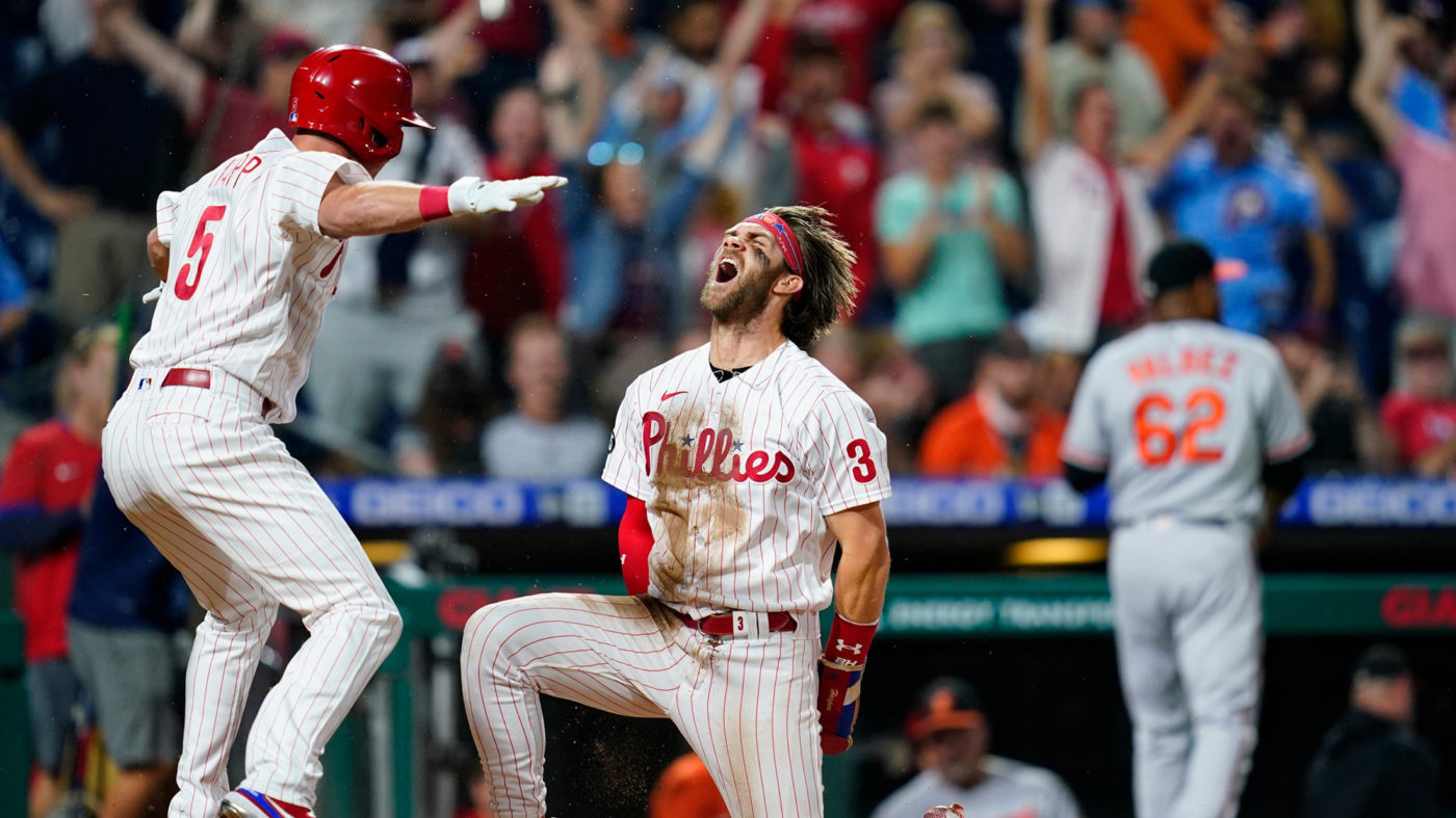 Philadelphia Phillies player Bryce Harper screams in triumph while kneeling on one knee after scoring at Citizens Bank Park in Philadelphia