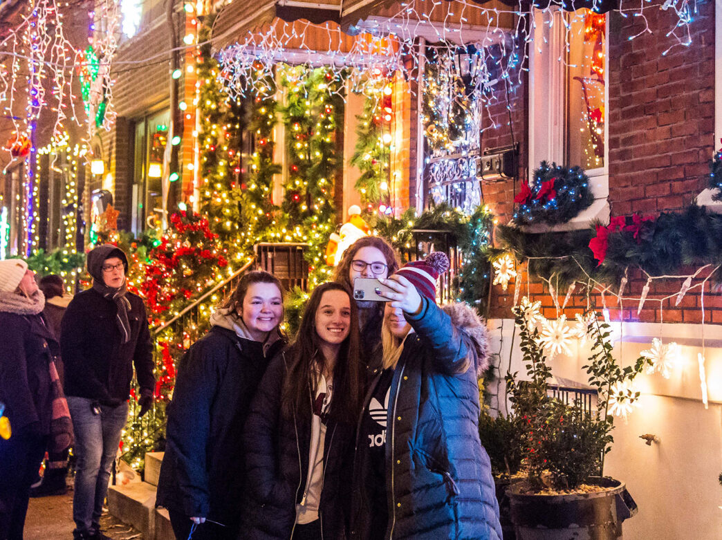 Des amis prennent un selfie devant les lumières du MIracle, sur la 13e rue sud à Philadelphie.