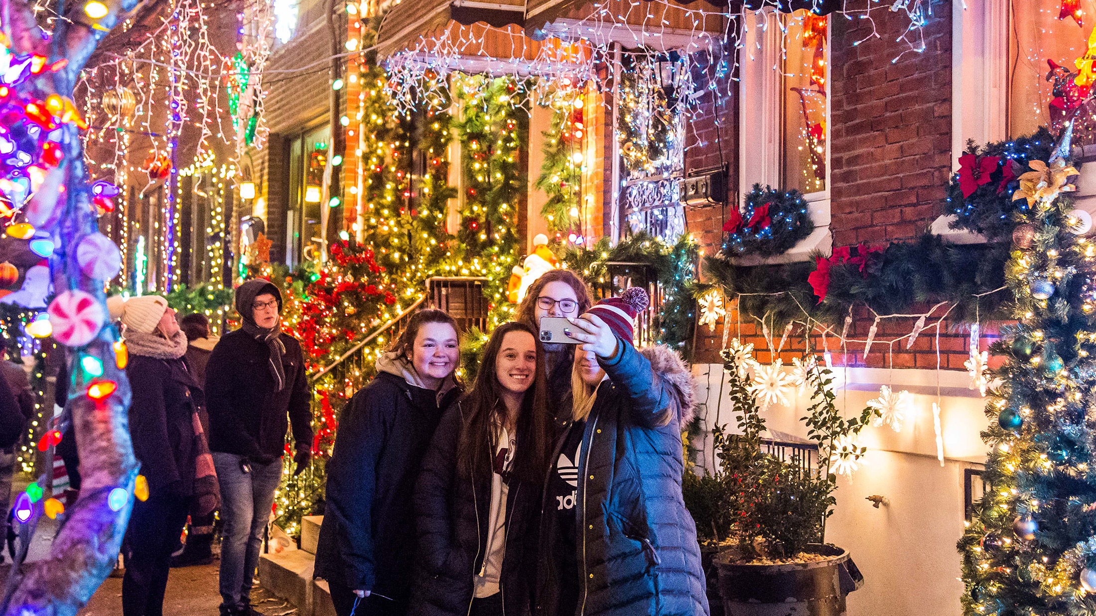 Friends take a selfie in front of the lights at MIracle on South 13th Street in Philadelphia